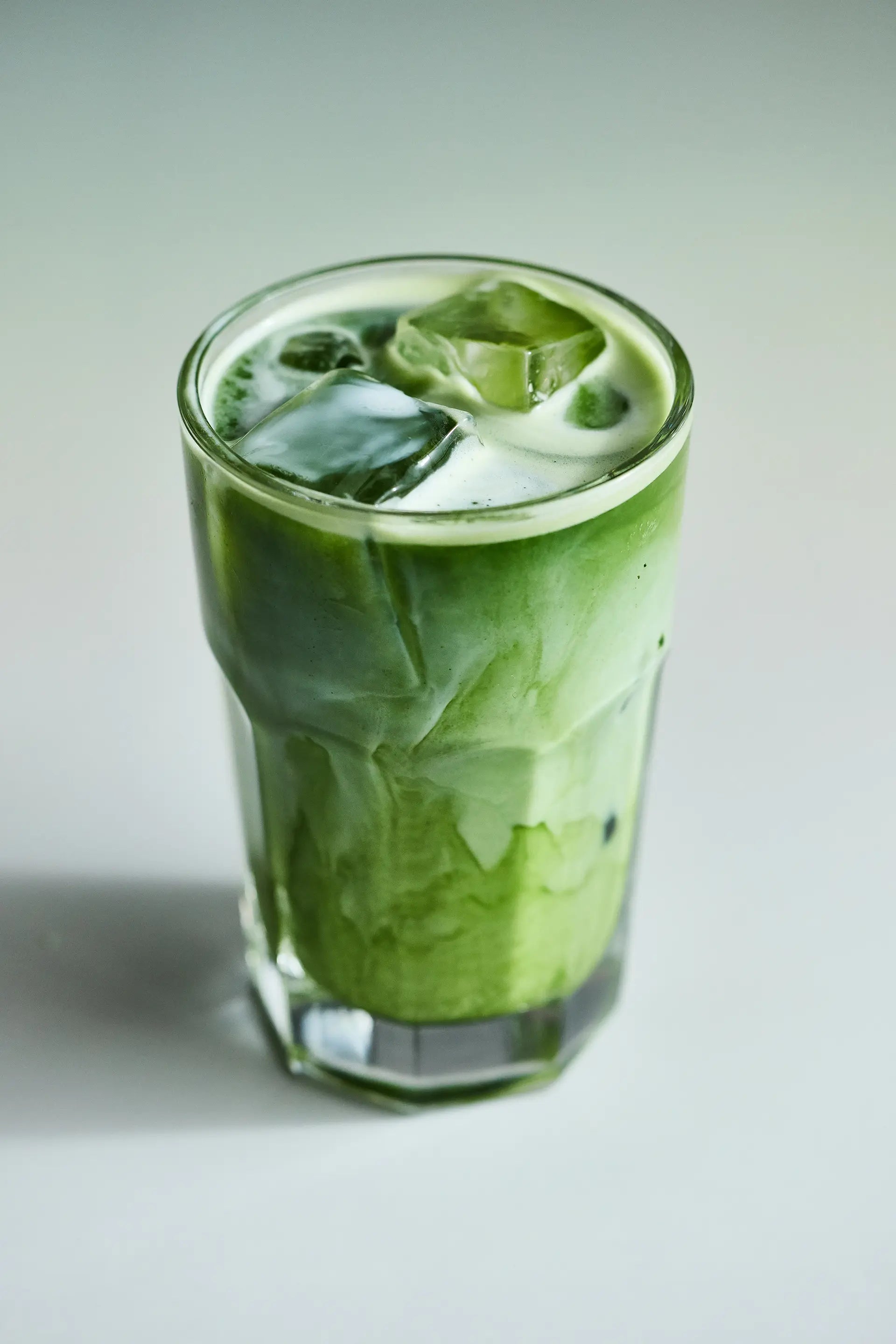 Matcha latte in a glass cup on gray background