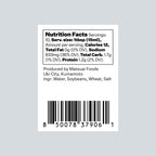 A Nutrition Facts label on a white rectangular card, showing text including 'Nutrition Facts', serving size, calories, total fat, sodium, total carbs, and protein, plus a barcode and production details for Matsui Foods. The card is centered on a light gray background.
