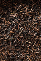 A close-up of Oyama Seicha hojicha, showing roasted brown tea leaves and stems with a mix of curled and twig-like pieces.