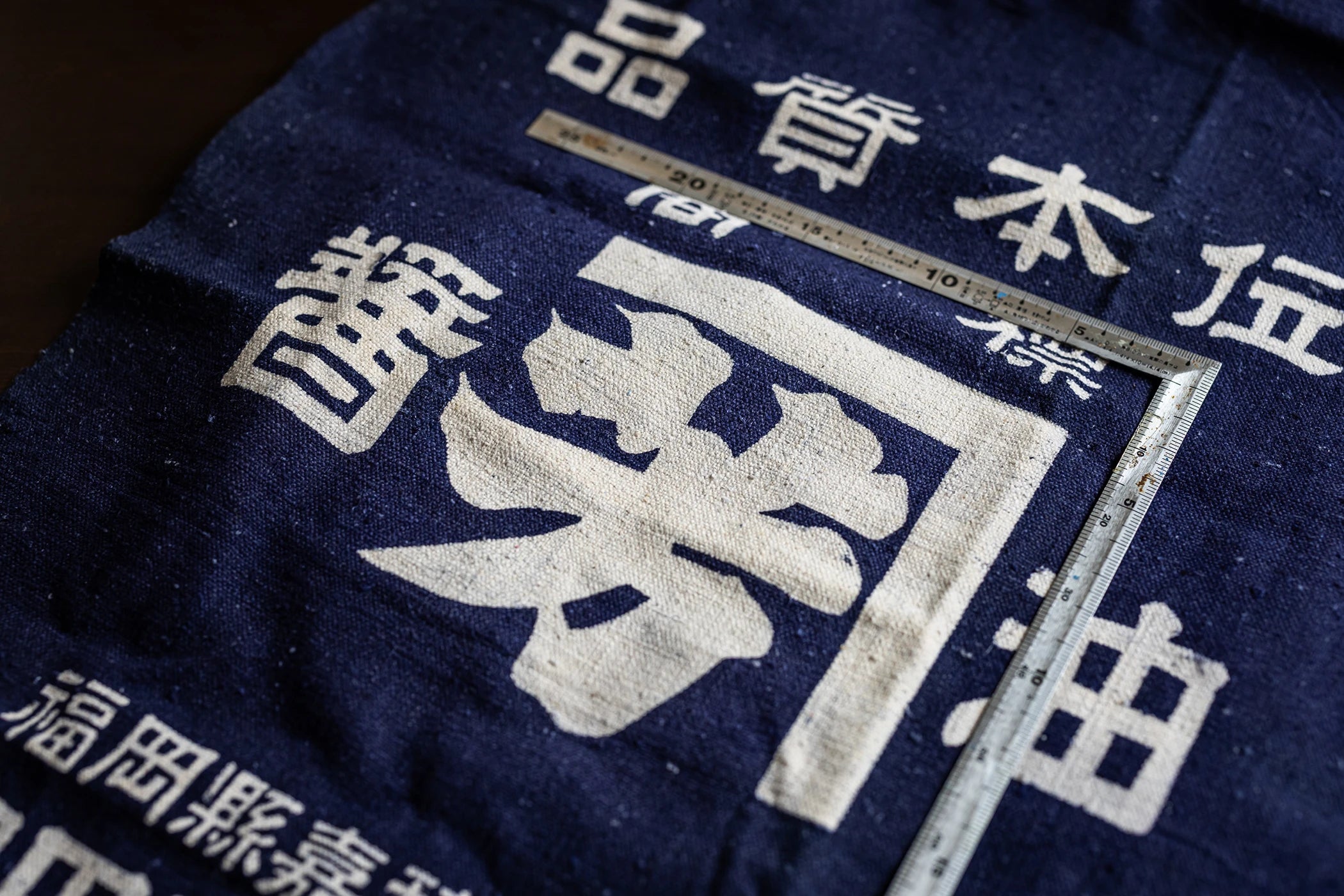 Vintage soy sauce canvas sack with white Japanese kanji characters at Kaneyoshi brewery.