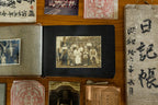 Vintage photo album with old photographs and documents on a wooden surface.