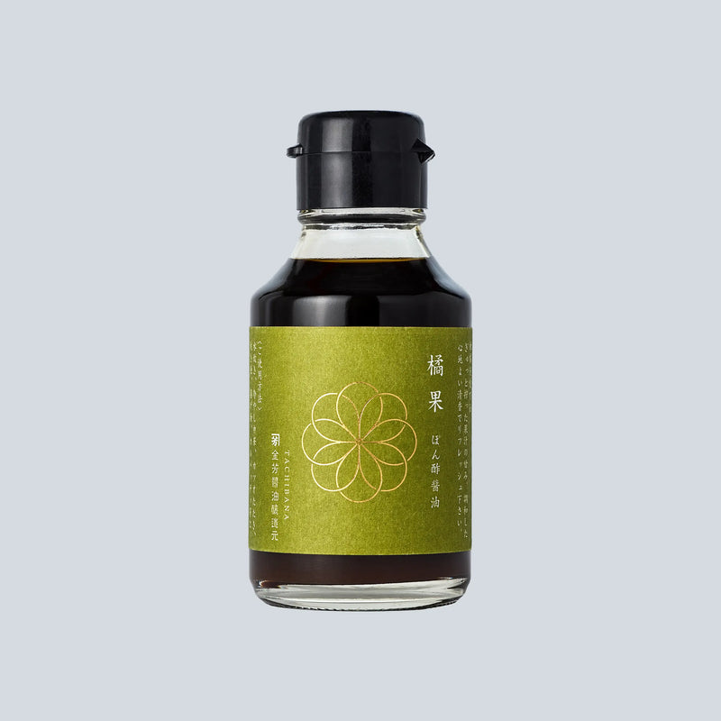 Bottle of soy sauce with a green label on a light gray background