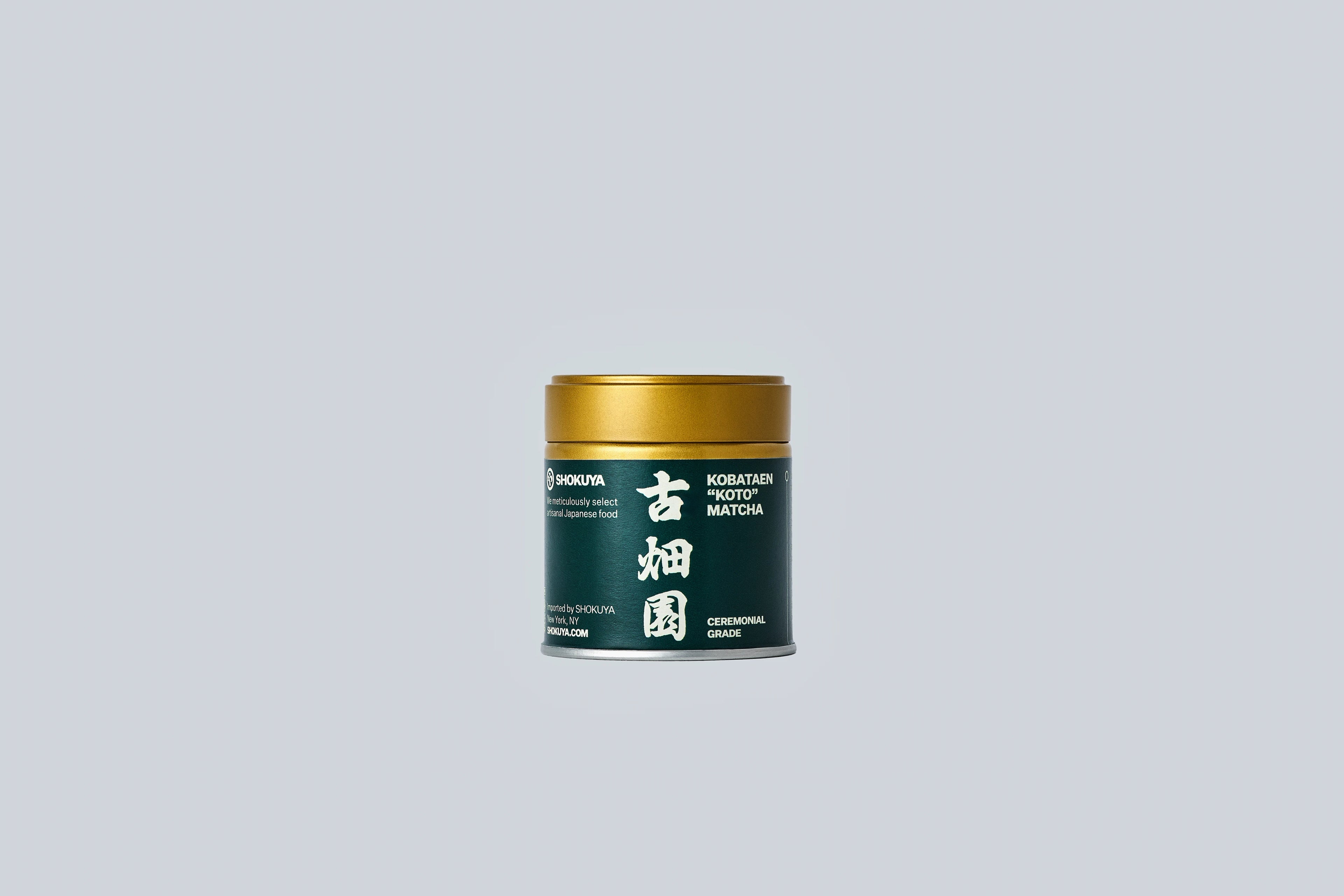 Container of matcha with gold lid and dark green label with white text on a light gray background