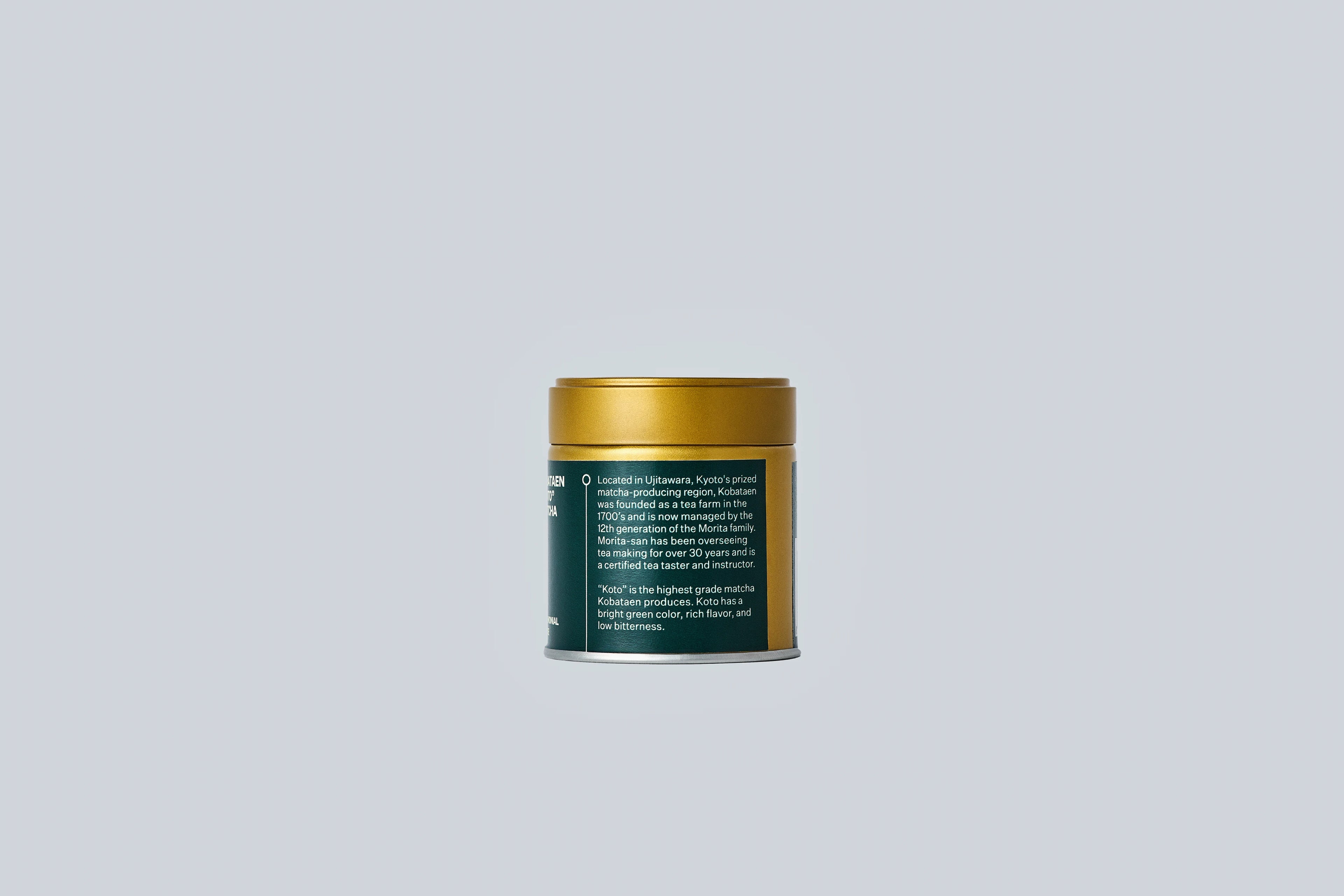 Container of matcha with gold lid and dark green label with white text on a light gray background