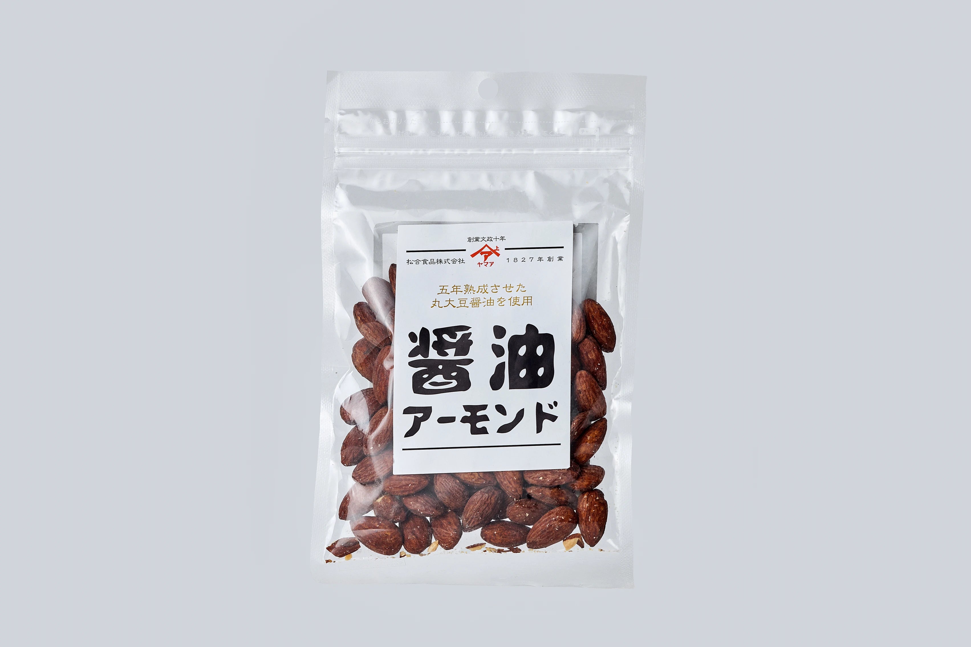 Clear bag of Matsuai Shoyu Roasted Almonds with white label on the front on light gray background