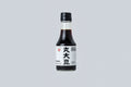 Bottle of soy sauce with a black cap on a light gray background