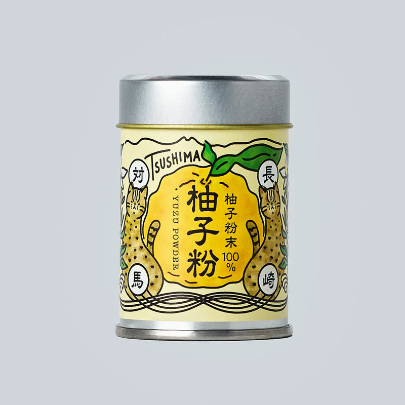 Small metal canister of Japanese yuzu powder from Oishi Farm centered on a light gray background, with a yellow illustrated label showing yuzu fruit and Japanese text.