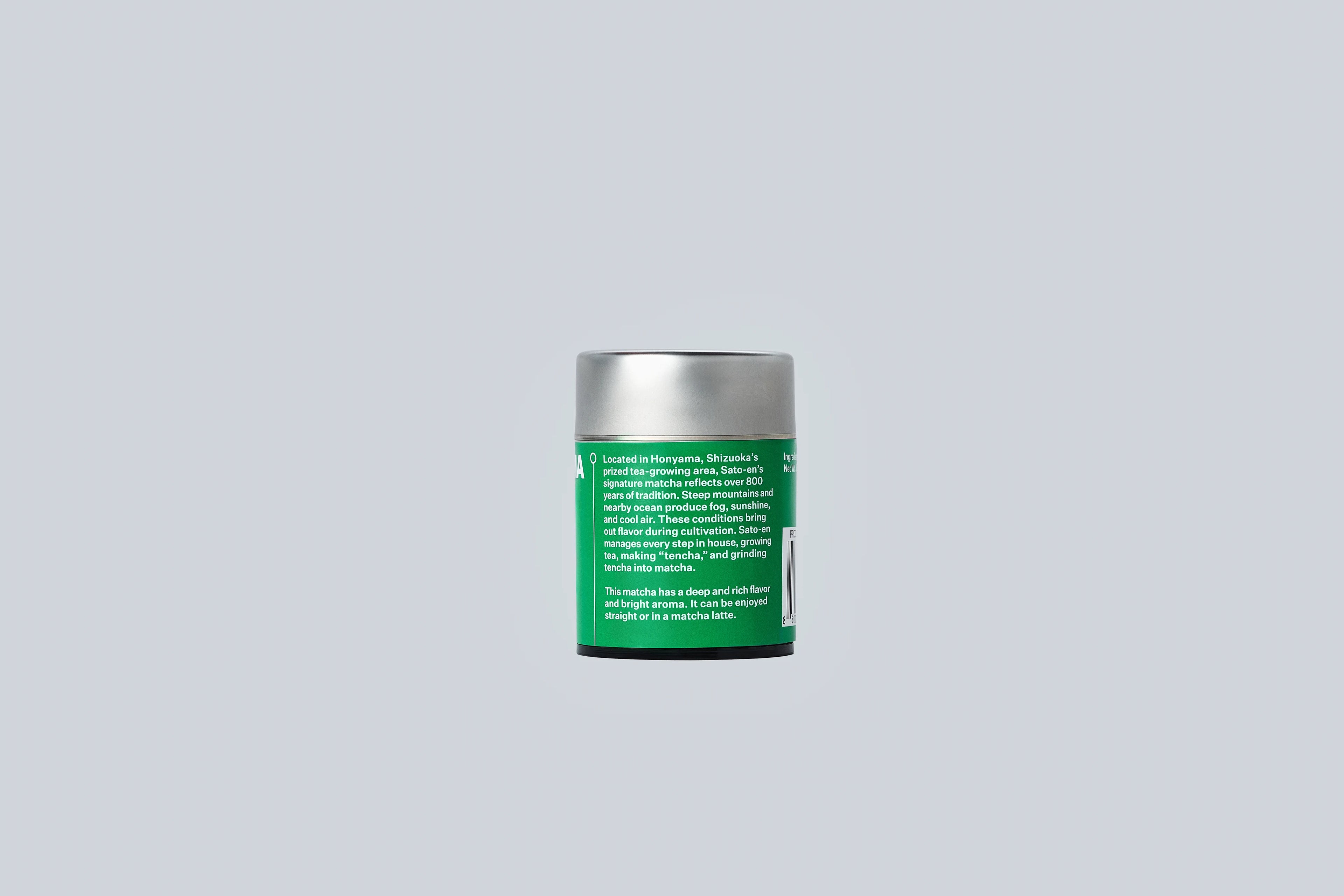 Silver canister with green label on a light gray background