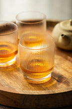 Oishi Black Tea with Yuzu in a class on a wooden tray.