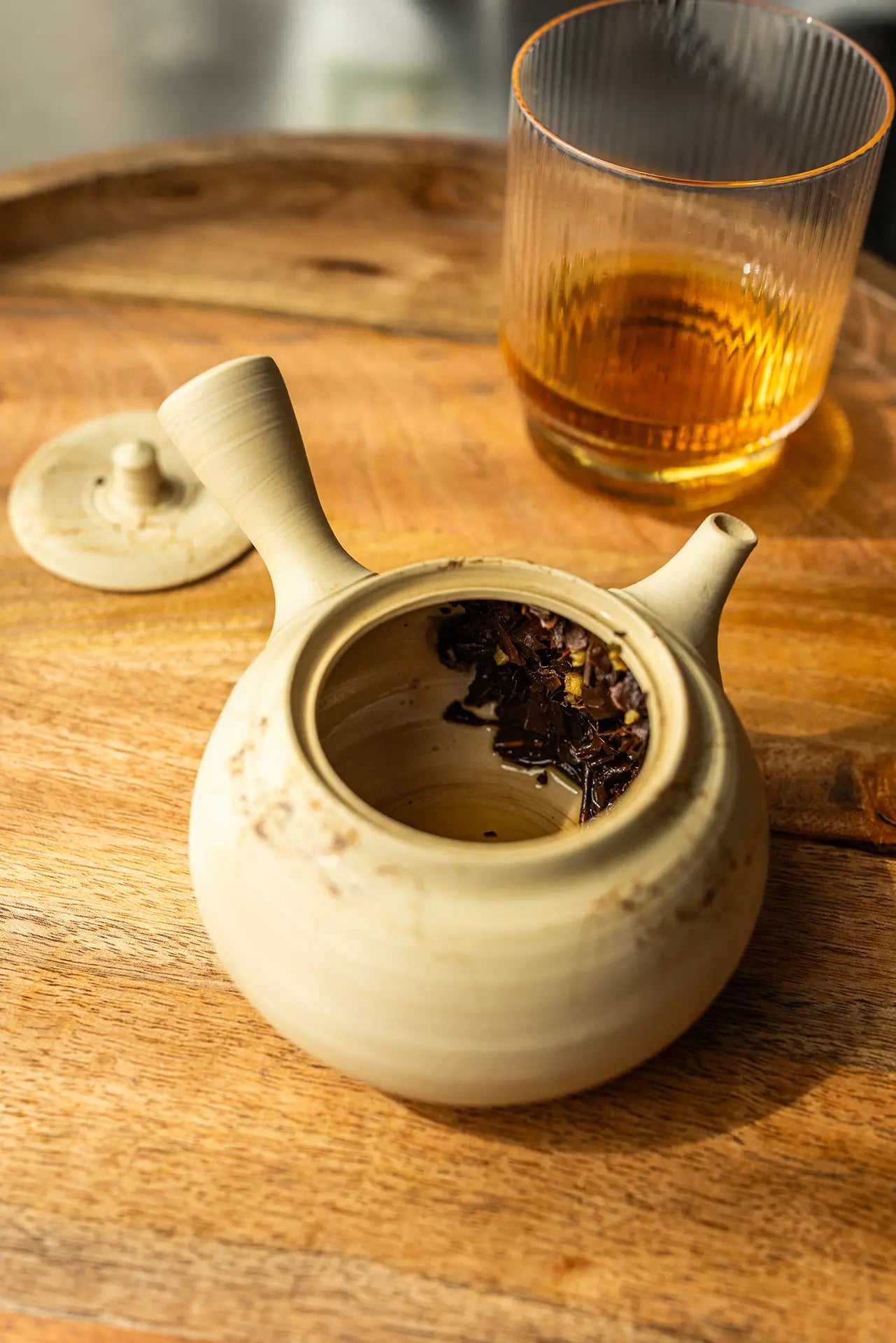 Oishi Farm brewed black tea leaves in a tea pot on a wooden tray